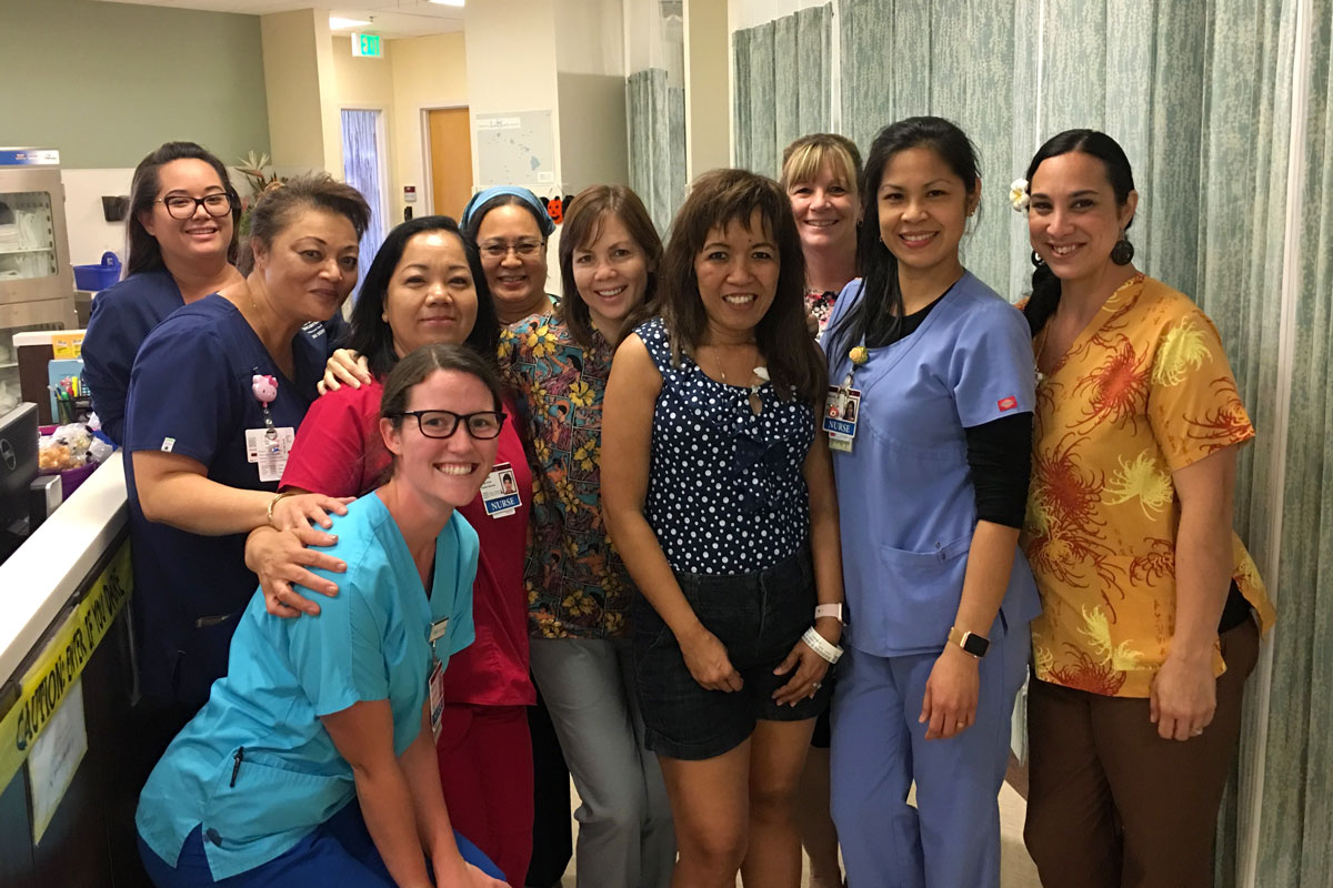 Cheri Beddow poses for a group photo with nurses in the Pali Momi Infusion Center