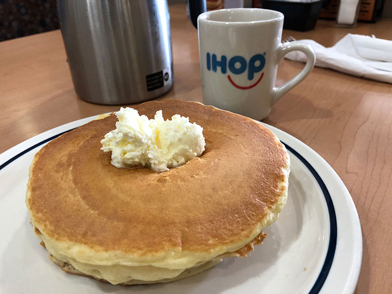 Plate of pancakes and a cup of coffee with IHOP logo