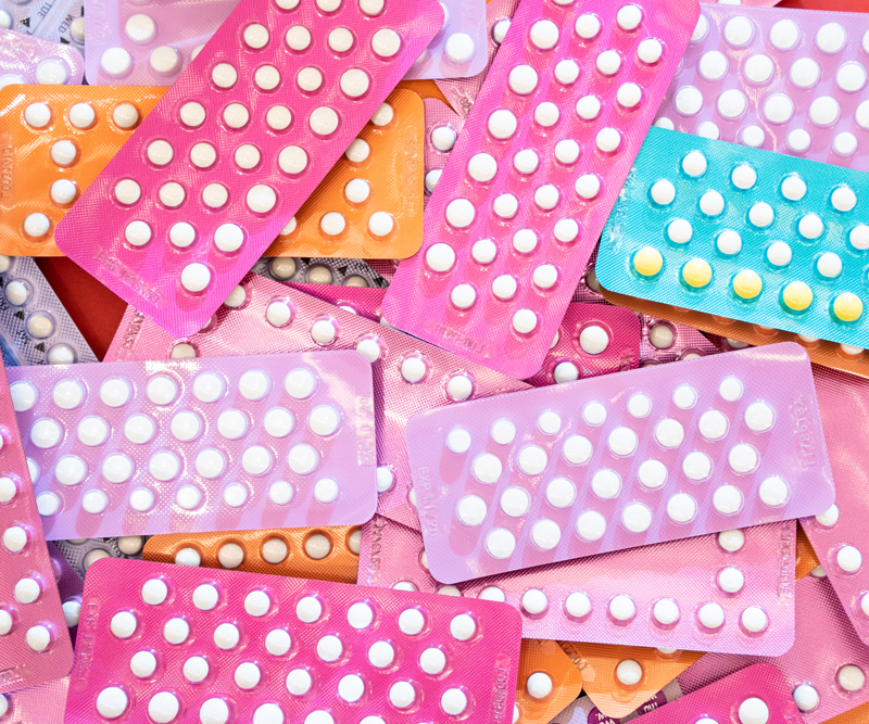 brightly colored packs of The Pill birth control method piled on top of each other