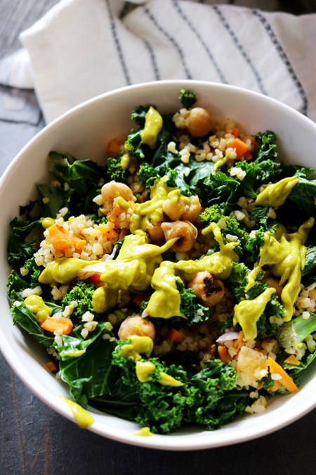 Protein-rich chickpeas combined with fiber-full carrots, kale and bulgur get topped with a generous drizzle of a thick homemade avocado dressing for a well-rounded one-bowl meal.