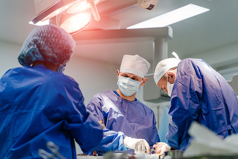 Three in surgical scrubs in operating room