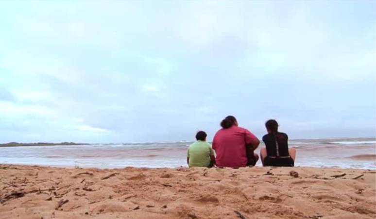 Bruce Naluai on the beach with family