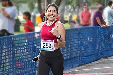 Woman runner smiling and throwing a shaka.