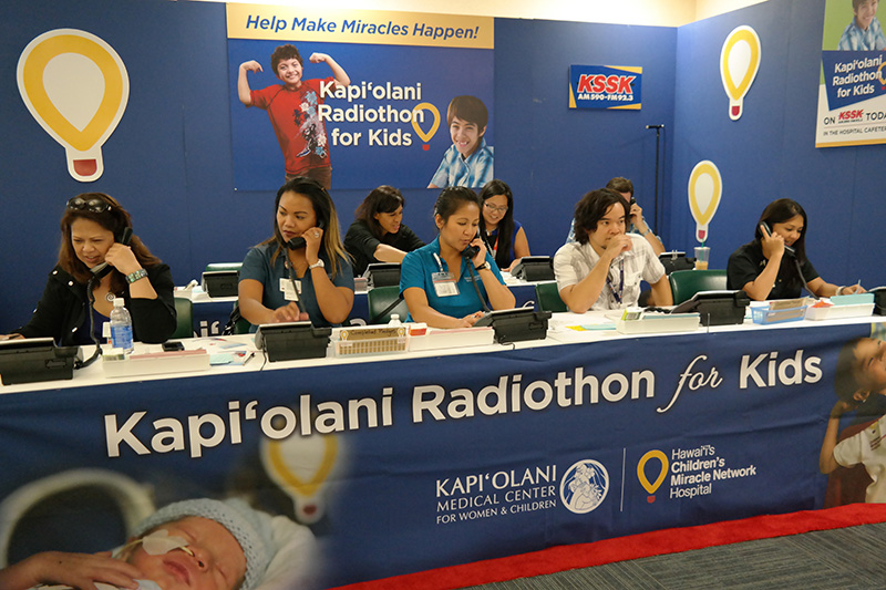 group of people taking phone calls at a children's miracle network radiothon event