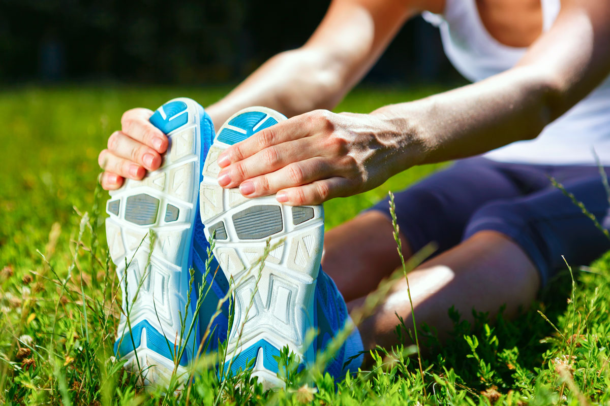 a runner stretching in a grassy field