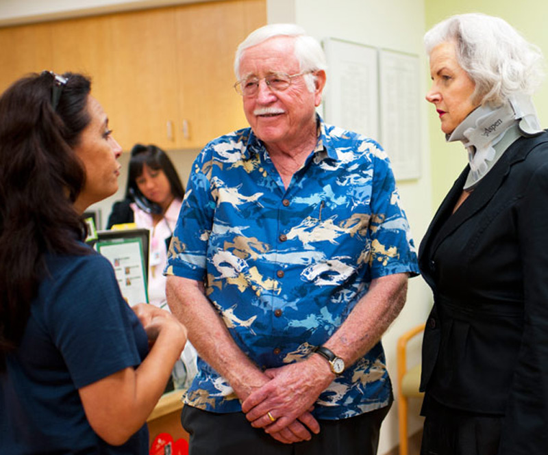 elderly couple speaking with a caretaker