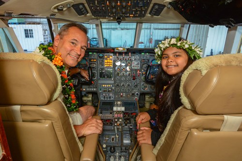 Emergency Airlift CEO Ed Langerveld sits in the cockpit of the Falcon 500 with 'co-pilot' Ashlyn, who was transported from Hawaii to Seattle Children's Hospital to receive emergency treatment for a heart condition.
