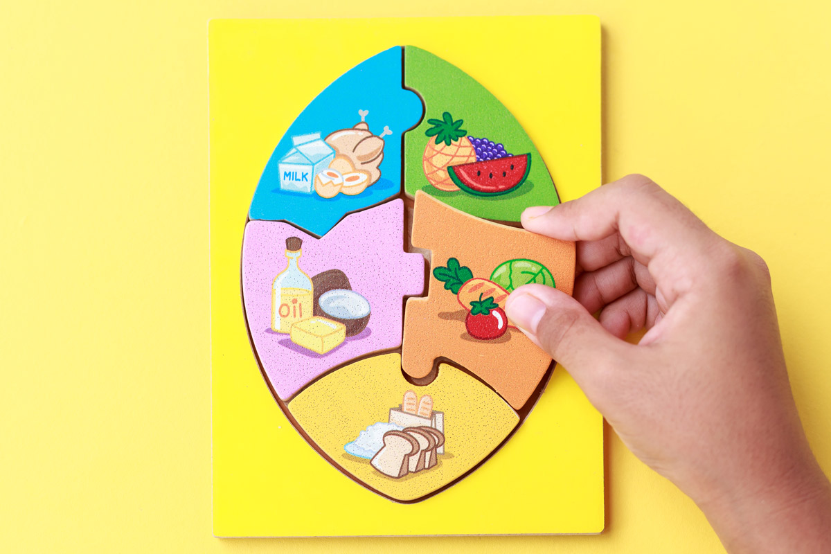 Child building a puzzle out of different food types