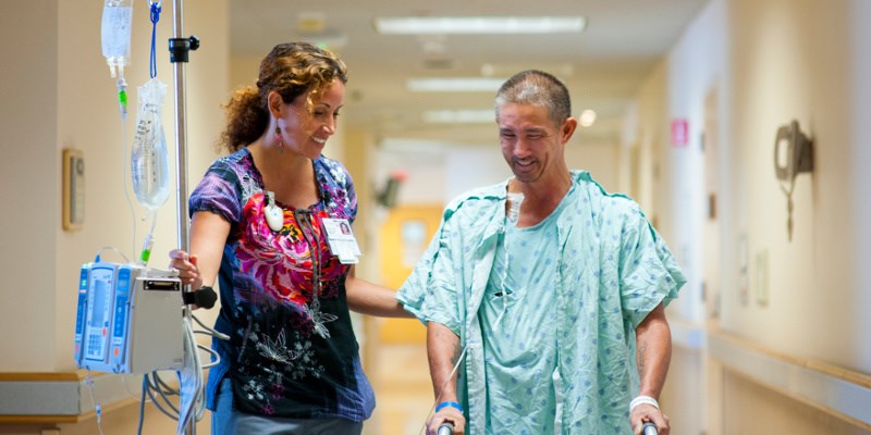 hospital patient being helped walking down the hallway