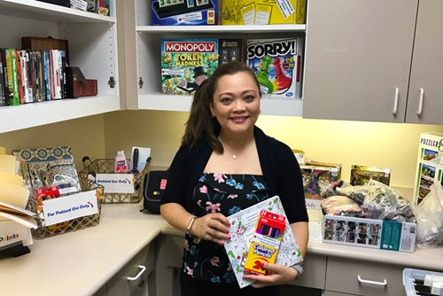 Maria Chorney displays some of the activities, including coloring books and board games, as part of the Antepartum Program at Kapiolani.