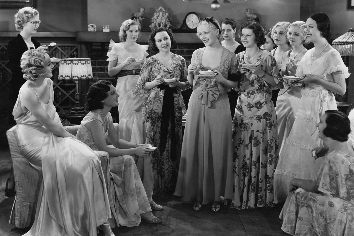 black and white photograph of a group of women at a dinner party