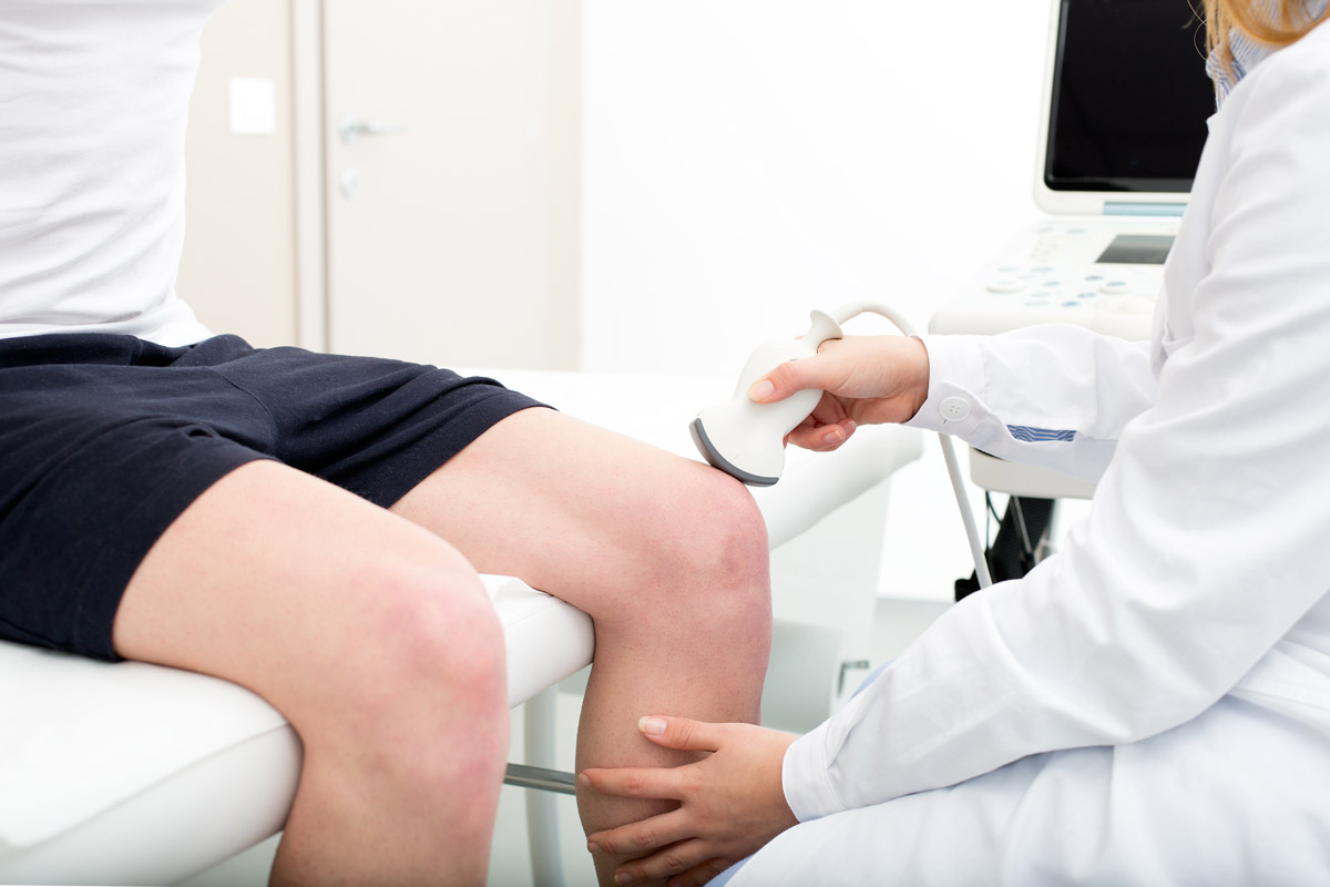 Doctor checking patient's knee