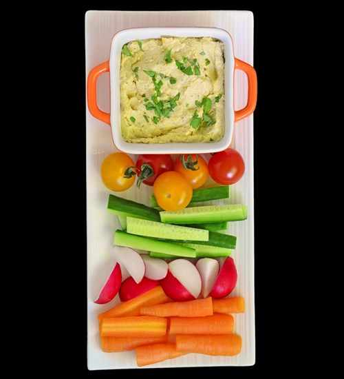 Another smart snack option – homemade hummus with colorful, fresh veggies.