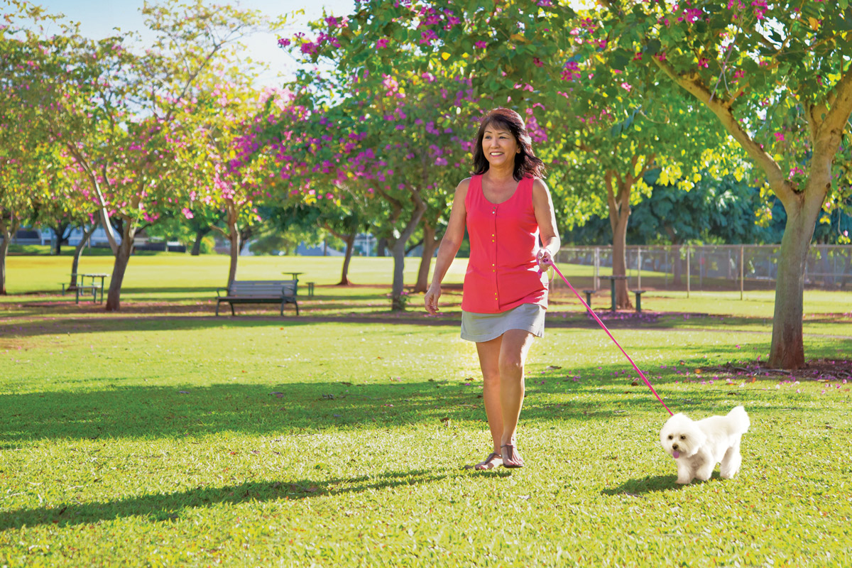Coleen Uyechi walking her dog in a park