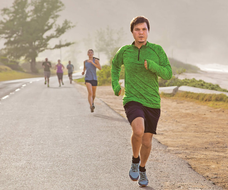 Casey Emmons running with a group of people by a beach