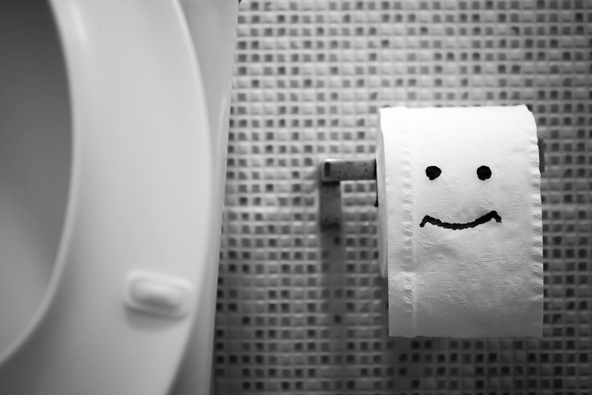 Close-up of a happy face drawn on a roll of toilet paper