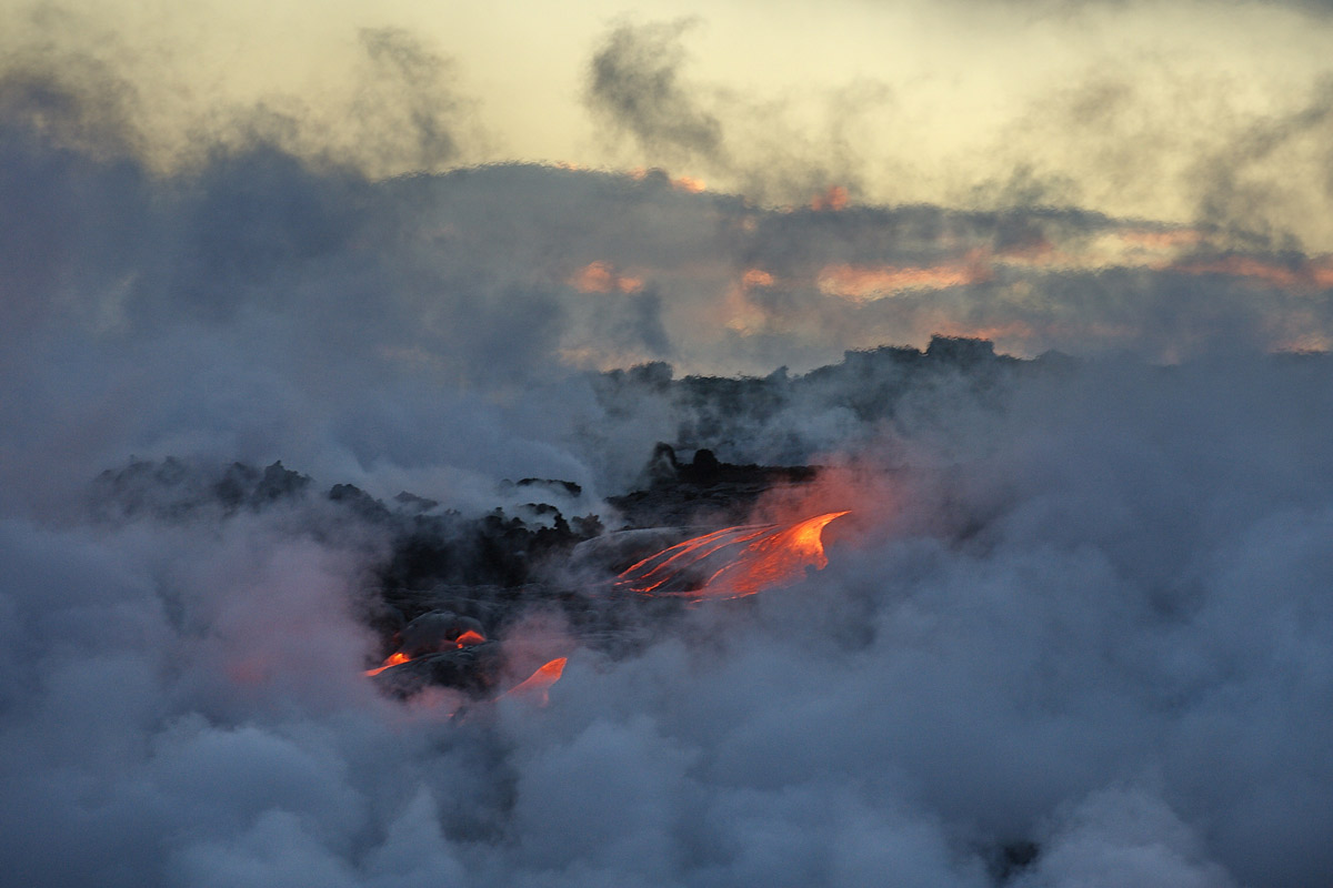 a thick layer of vog clouds the air around an active lava field