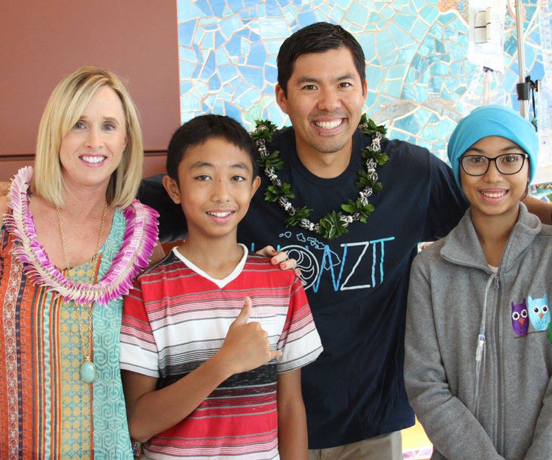 Kurt and Renee Suzuki flash a smile with two young patients at Kapiolani Medical Center.