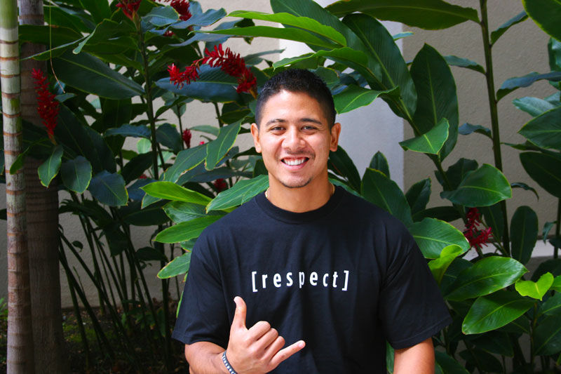 a guy wearing a respect shit smiling and showing a shaka
