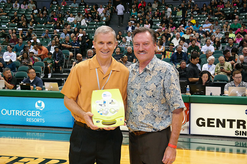 Gladstone is pictured above (right) presenting one of the seven AEDs to UH Associate Athletics Director Carl Clapp at the Jan. 25 men's basketball game versus UC Riverside.