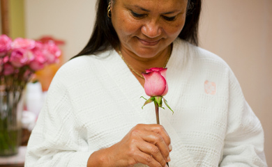 women smelling a pink rose