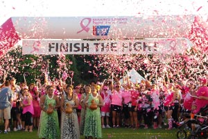 women at the finish line of making strides with pink confetti