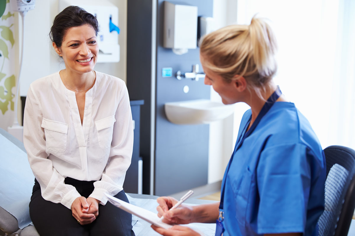 woman talking to female doctor about her health history during an annual exam