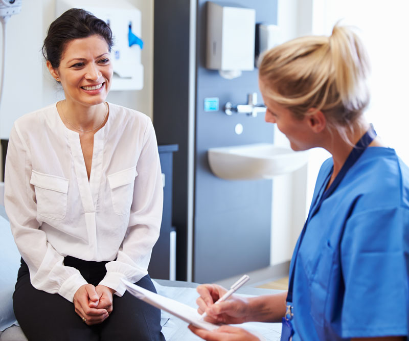 woman talking to female doctor about her health history during an annual exam