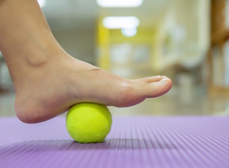 Rolling your injured foot on a tennis ball or frozen water bottle can help relieve pain from plantar fasciitis.