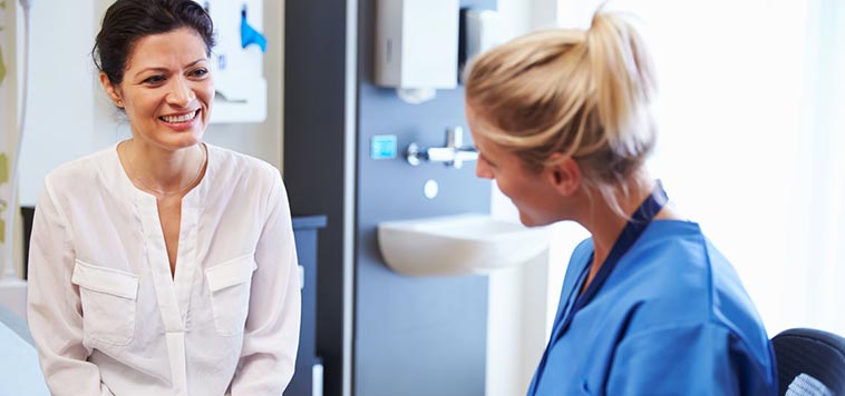 woman talking to female doctor about her health history during an annual exam