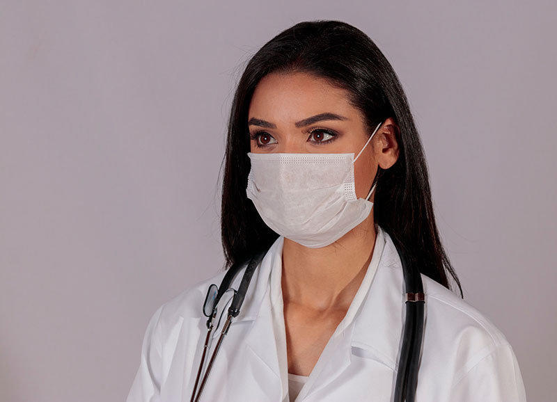 Female doctor with a stethoscope wearing a mask