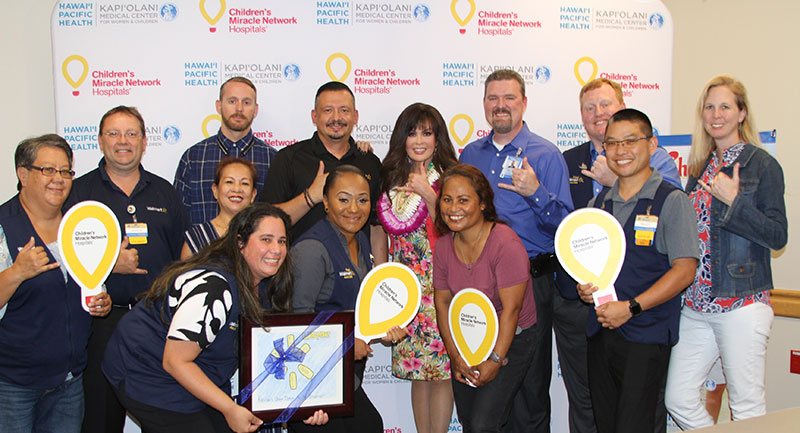 Group of people holding Children's Miracle Network balloons