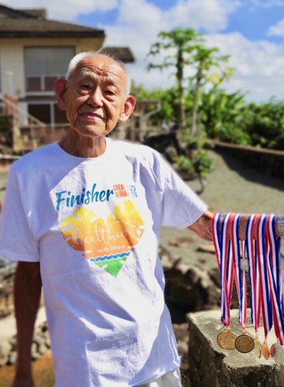 Hung Lum flashes his medals, along with his finisher's shirt from the 2018 Hawaii Pacific Health Great Aloha Run.