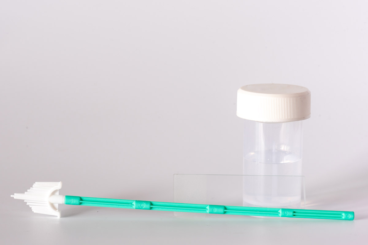 Liquid-based cytology solution bottle, cervical brush and glass slide set on white background