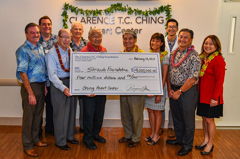 Group of 10 men and women holding ceremonial check for $4 million