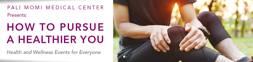 women in work out clothes sitting on the ground holding her knee