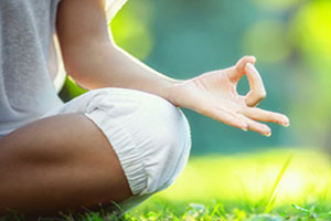 women sitting on the grass doing yoga