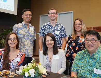 Hawaii Pacific Health employees at the of Hawaii Cancer Center’s first Annual Cancer Clinical Research Accrual Leaders (ACCRUAL) event sitting and standing at a table