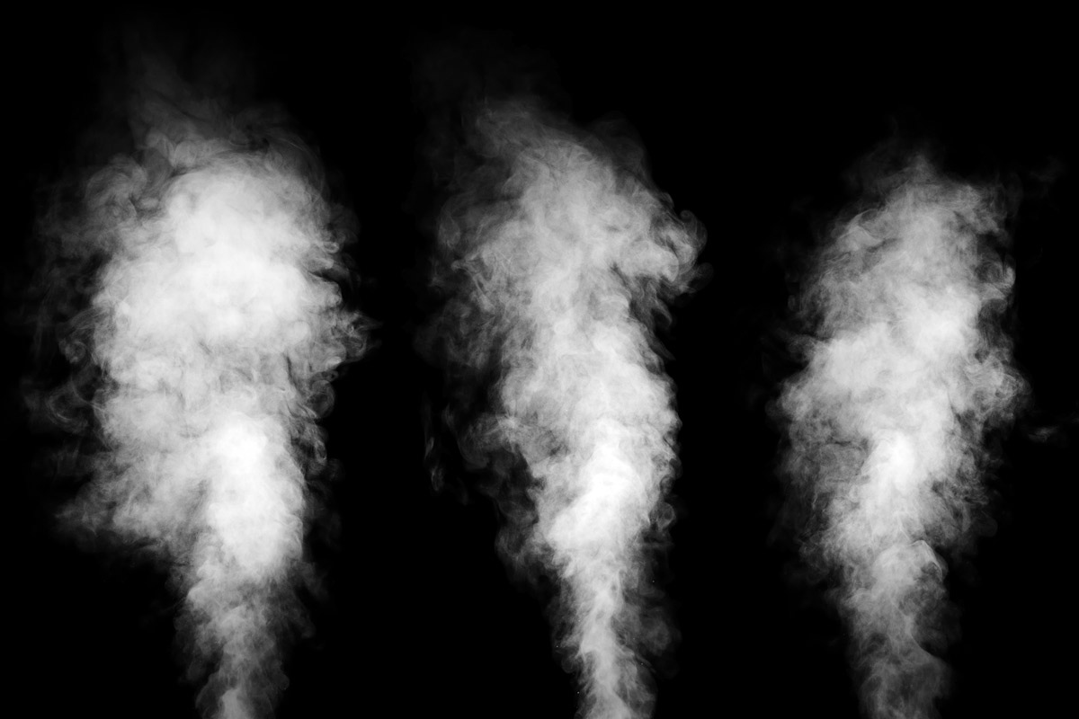three blasts of white steam shoot upward in front of a black background