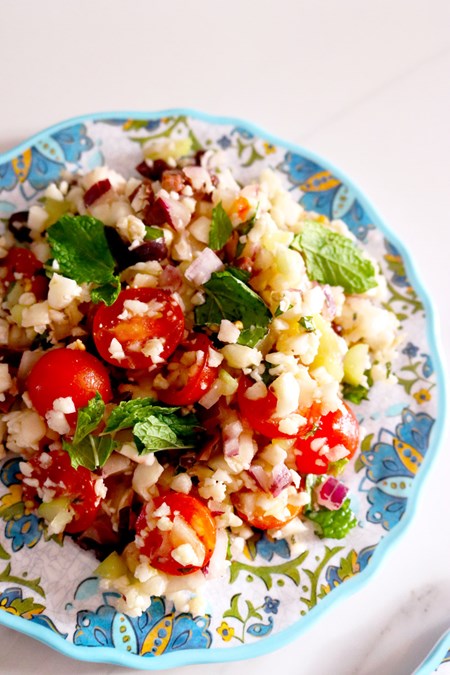 Tomatoes, cucumber, onions, cauliflower and olives mix beautifully with fresh herbs and a citrusy vinaigrette to create an edible garden on a plate.