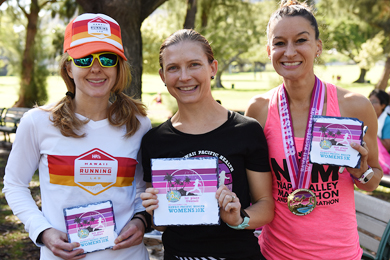 Female Runners showing their certifications and medals