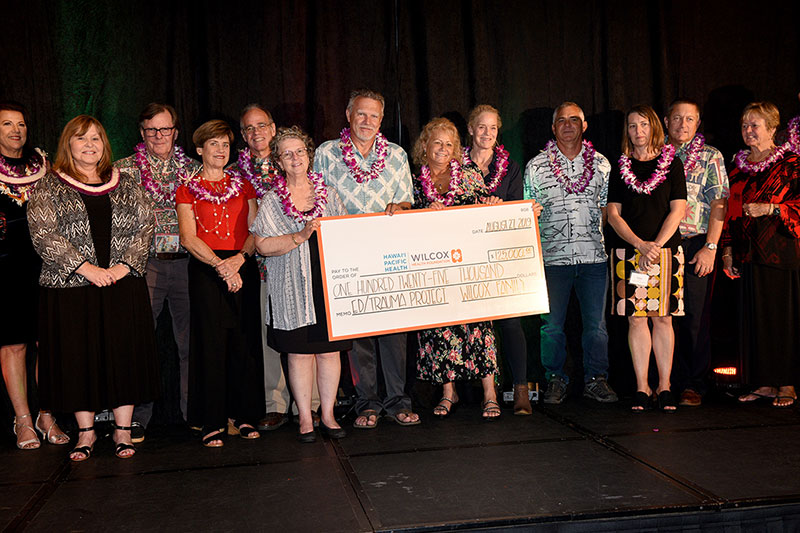 Large group of people on stage with ceremonial check for $125,000