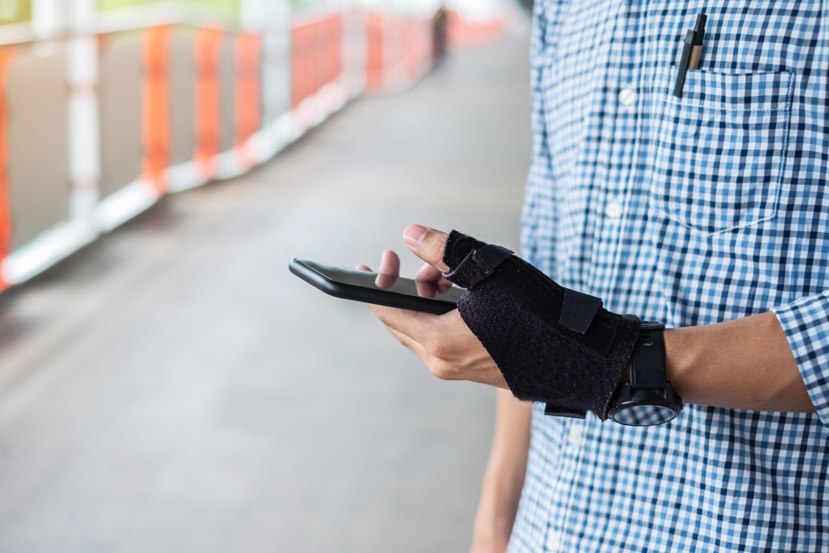 man with brace on wrist texting