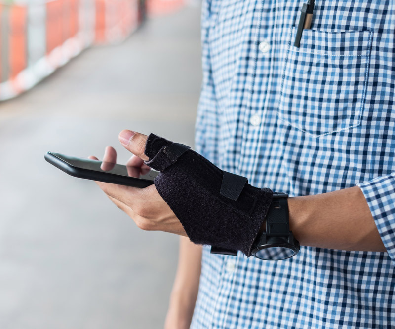 man with brace on wrist texting