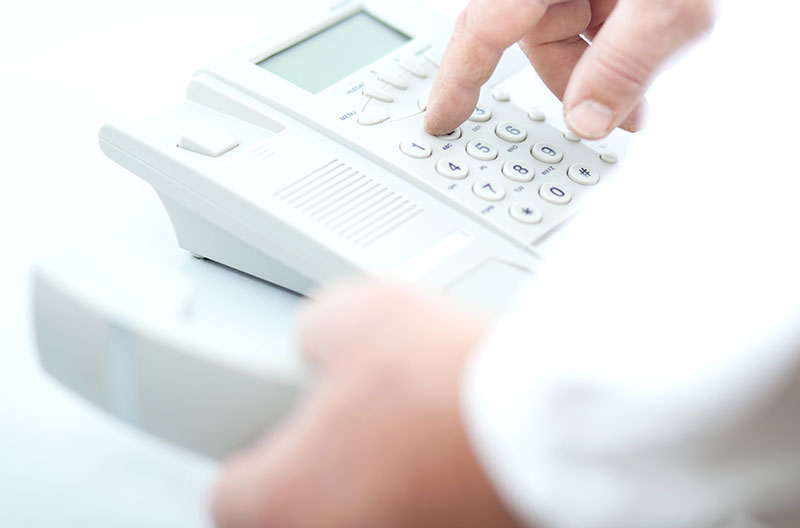 Doctor's hand pressing buttons on a telephone