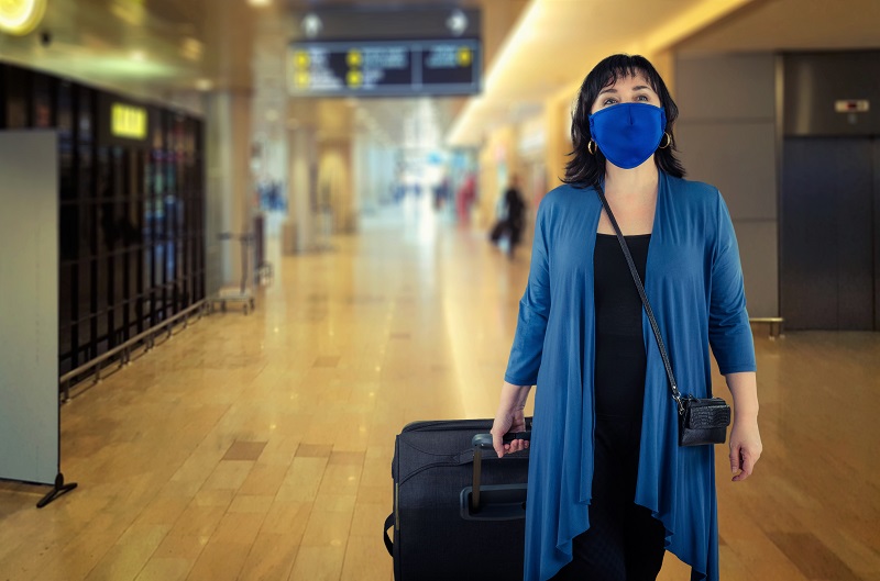 Woman wearing mask walking through airport
