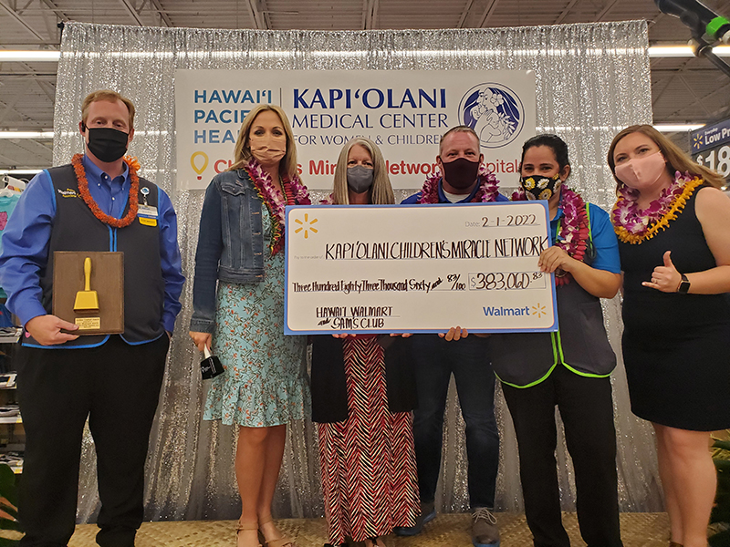 Group of five people standing with ceremonial check