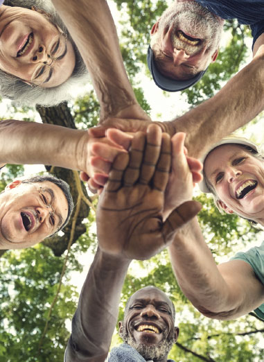 People smiling and looking down in a circle.