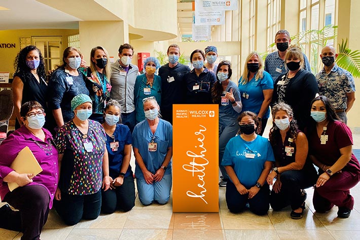 Large group shot of Dr Pricilla Chan, Mark Zuckerberg, and Wilcox Medical Center leadership and staff