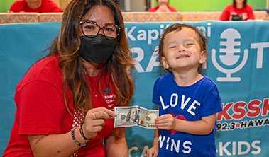 Young child gives Radiothon volunteer $100 bill as a donation